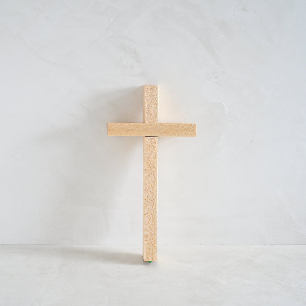 Wooden cross on a white limewash background
