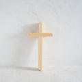 Wooden cross on a white limewash background