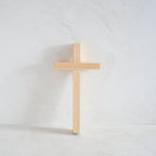 Wooden cross on a white limewash background
