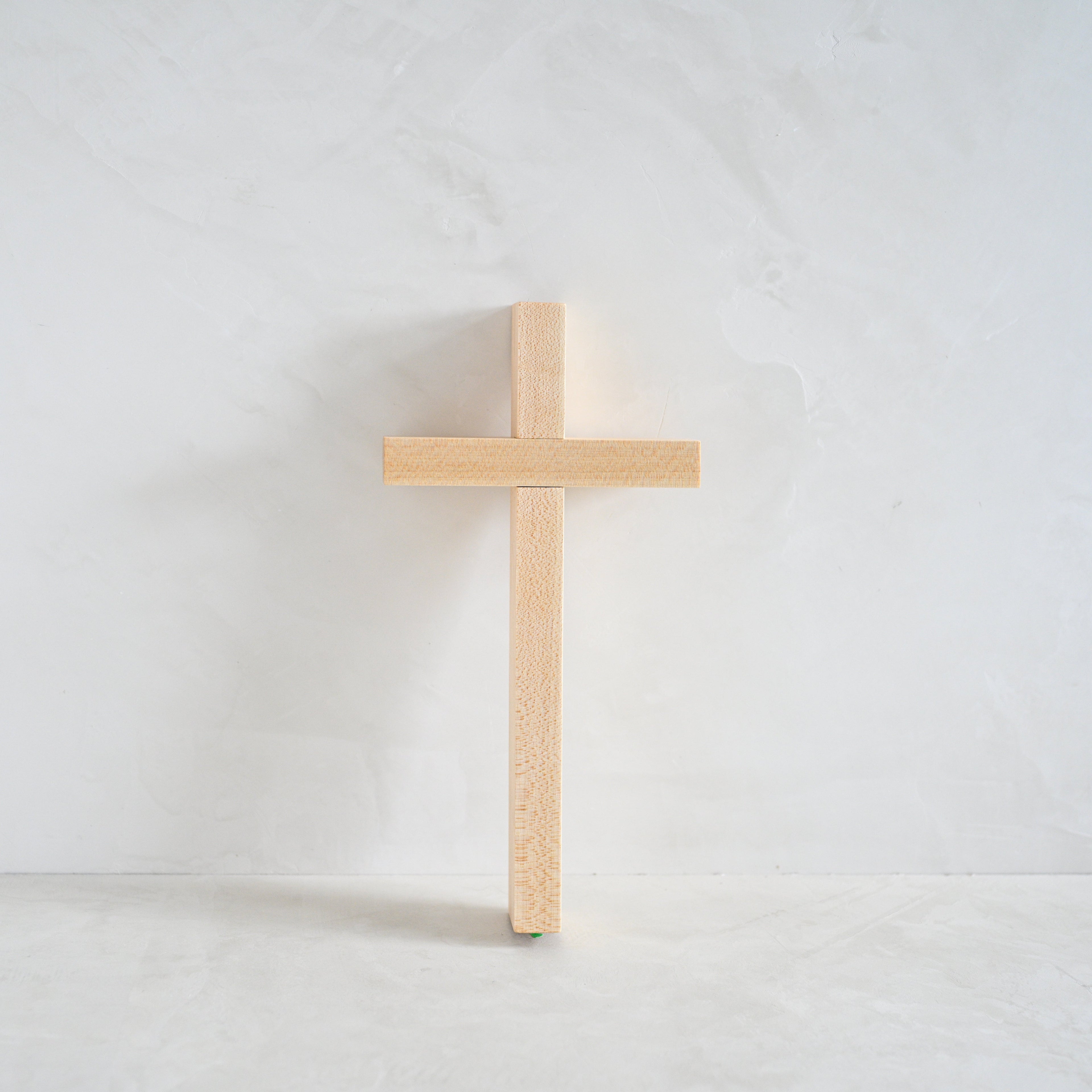 Wooden cross on a white limewash background
